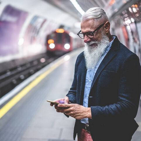 Senior hipster man using smartphone in subway underground - Fashion mature person having fun with technology trends waiting his train - Joyful elderly lifestyle concept - Main focus on face